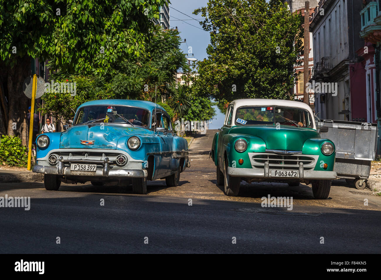 A pair of old cars pull away from a side road onto San Lazaro in Havana. Stock Photo