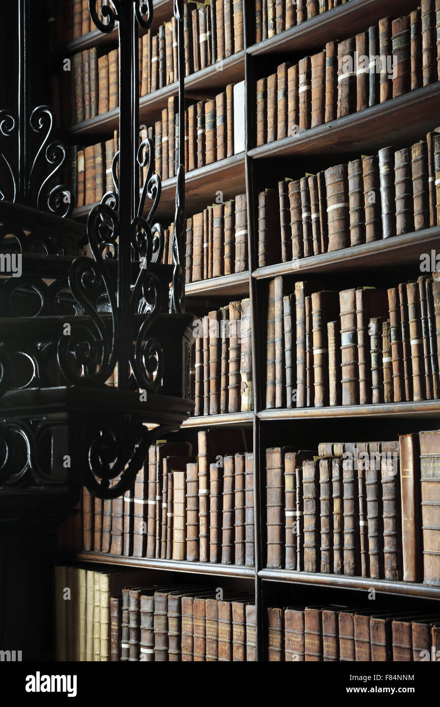 Antique books stored on the bookshelves inside of the Long Room of the