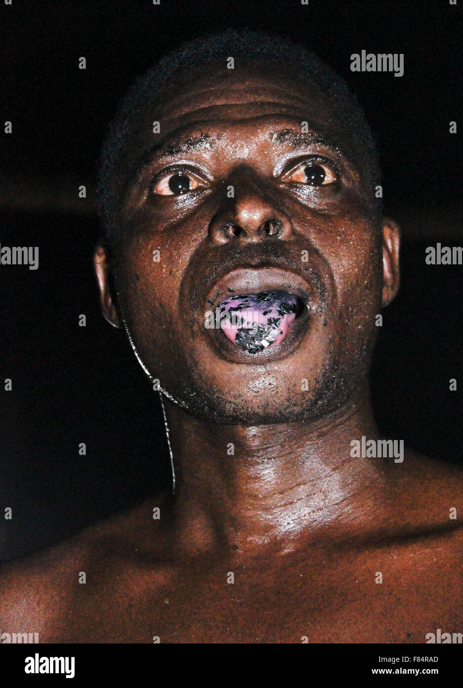 Man chewing razor blades at Bassare T'Bol fire dance, Sokodé, Togo Stock Photo