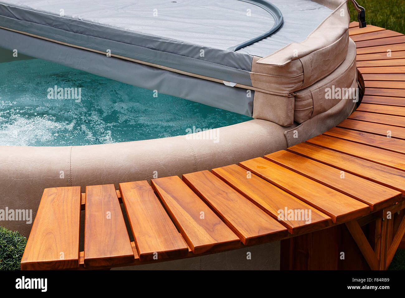 The ultimate garden accessory a free standing cedar wood and leather circular hot tub with cover. Stock Photo