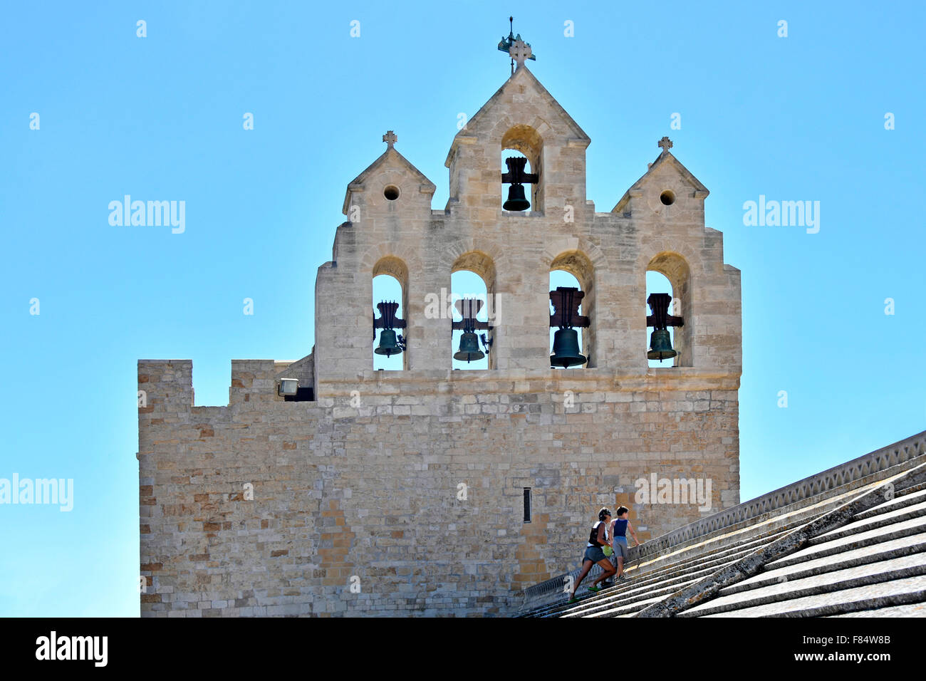 Bell tower and belfry with tourists paying for sightseeing on roof of the church Les Saintes-Maries-de-la-Mer in Saintes Maries de la Mer France Stock Photo