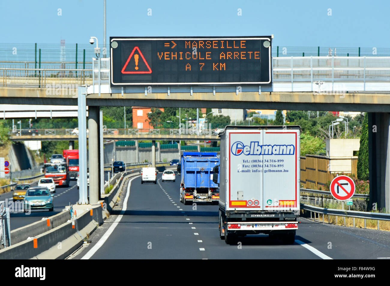 French autoroute motorway road rear and back view of lorry traffic below gantry mounted electronic information sign in Provence France Stock Photo