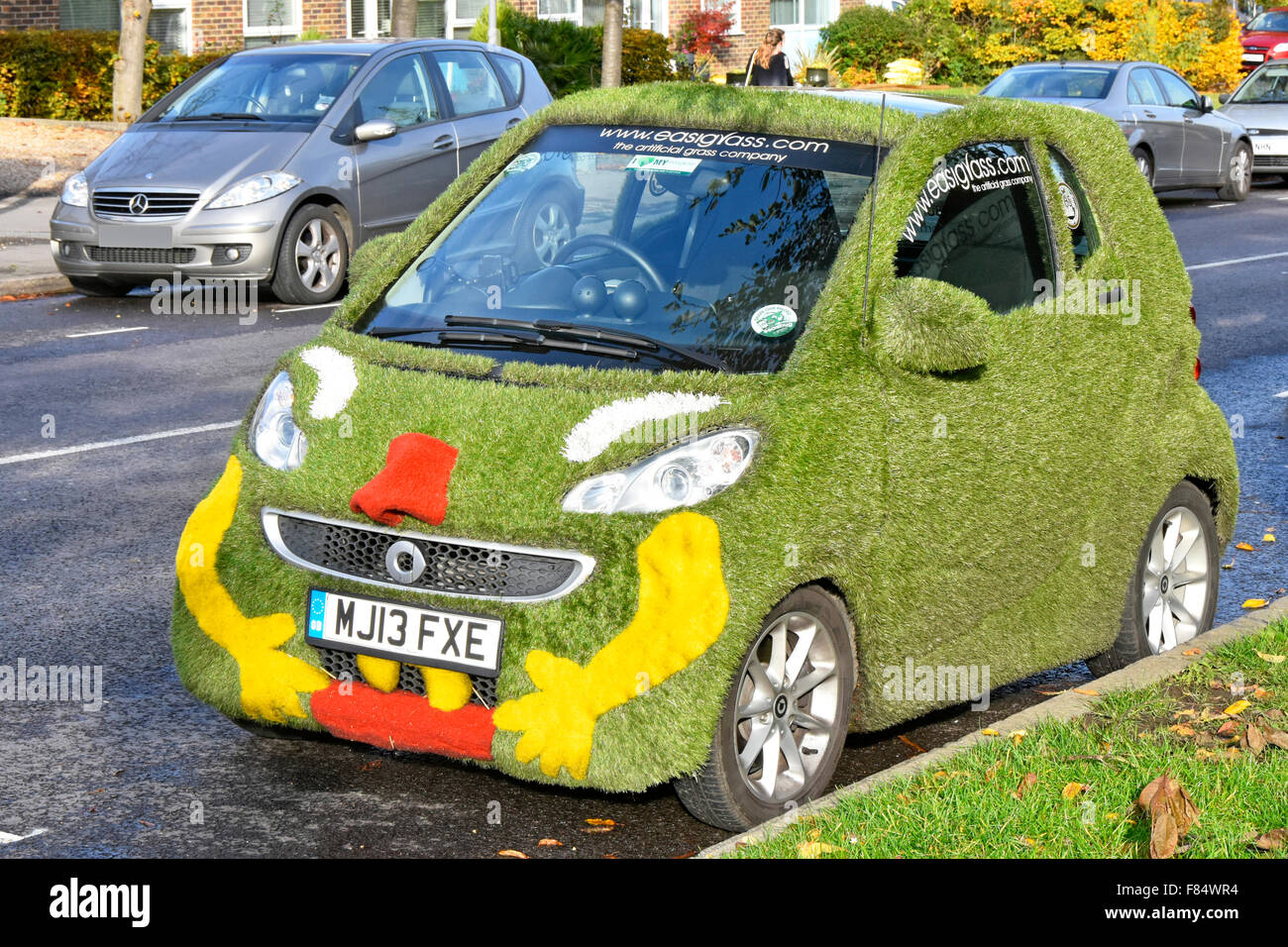 Smart car covered in fake grass lawn unusuak mobile advertising for artificial grass material for gardens Essex England UK Stock Photo