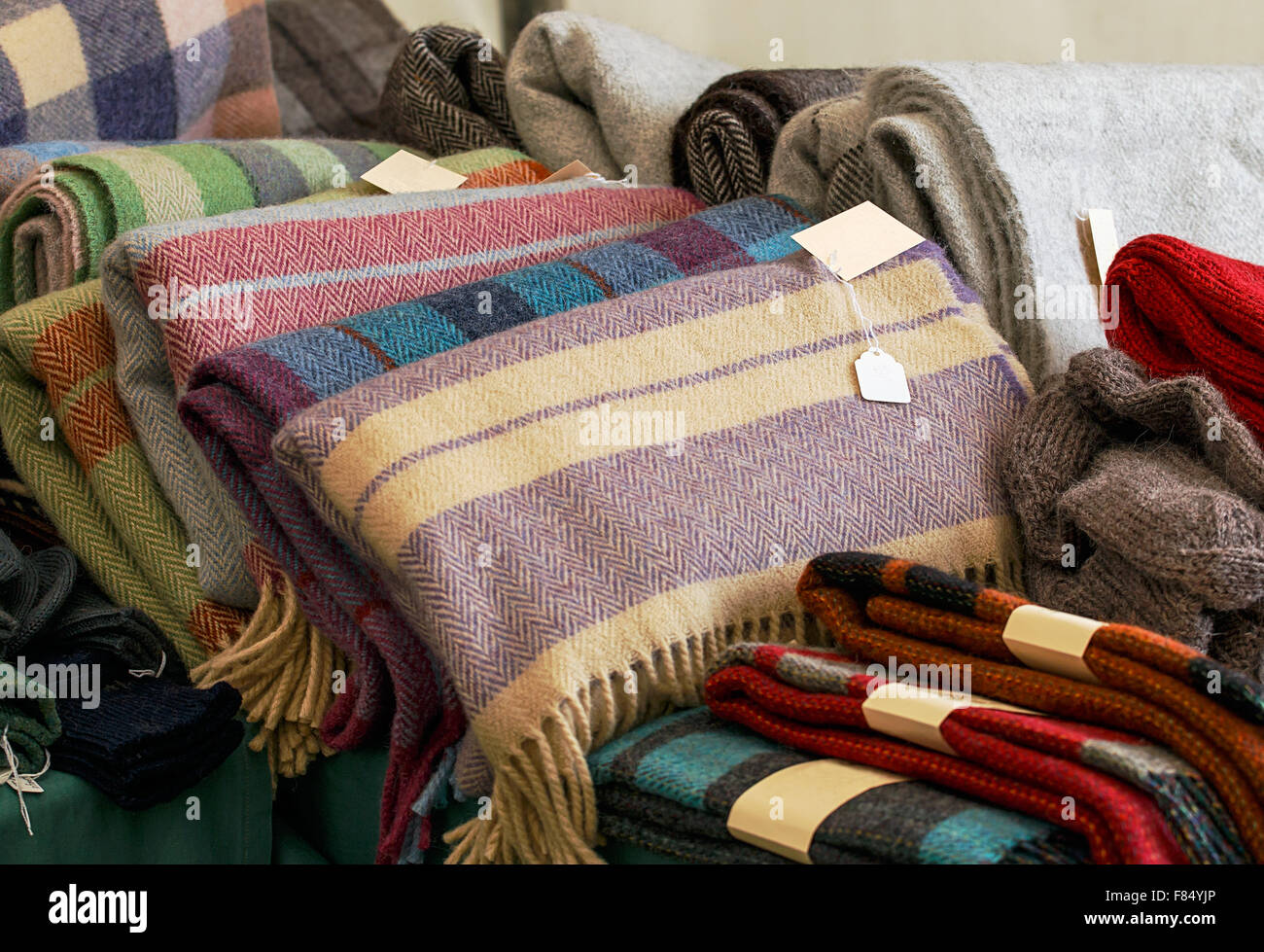Selection of throws traditionally made of wool in a pile for sale at market traders, great example of crafting industry. Stock Photo