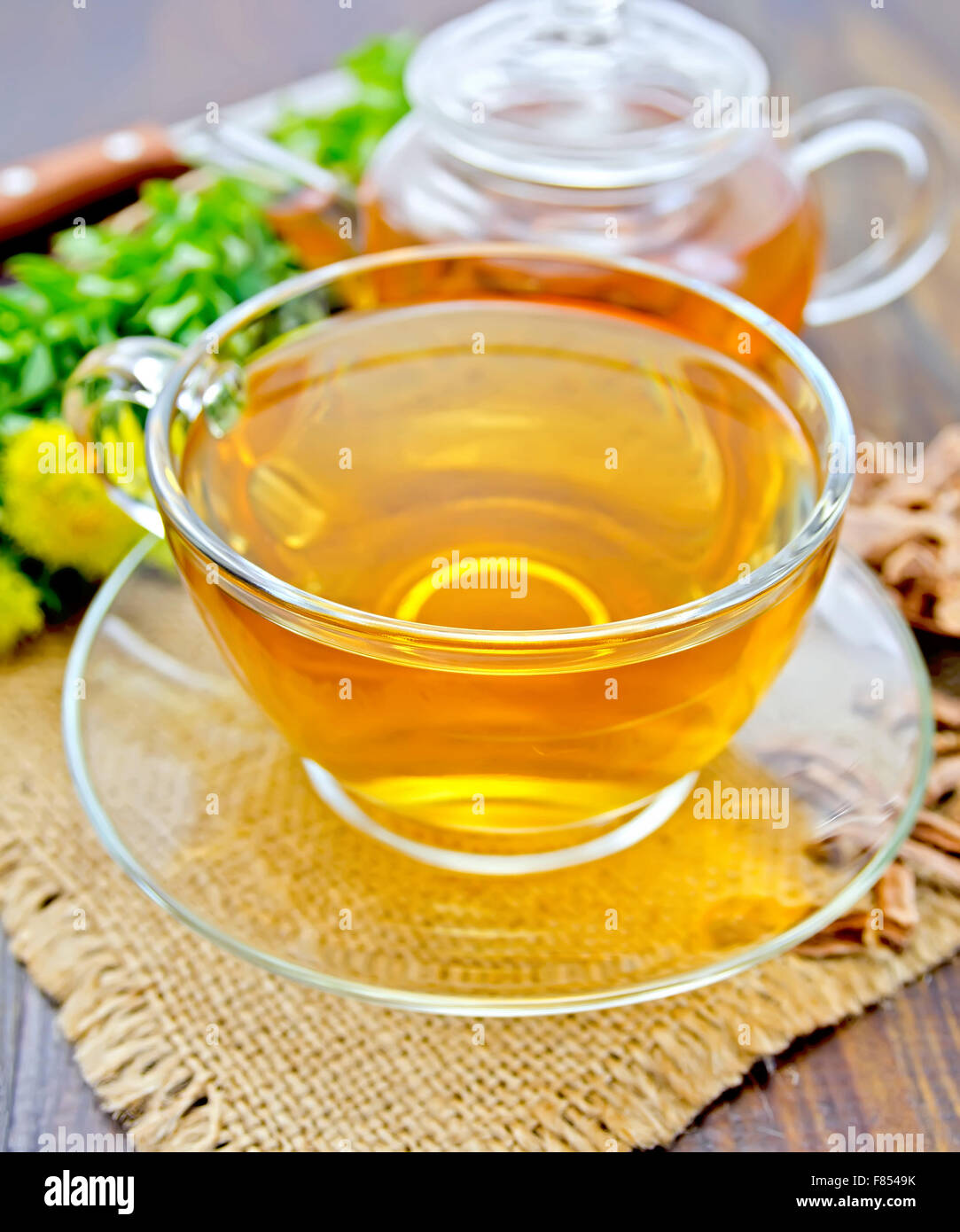 Tea of Rhodiola rosea in glass cup and teapot on sacking Stock Photo