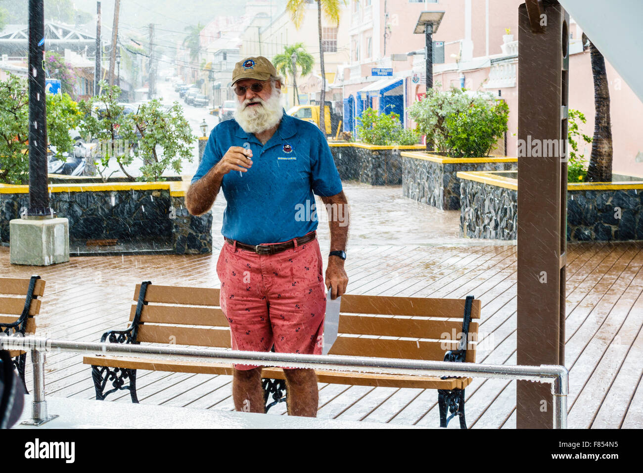The owner of Big Beards Charter company in Christiansted, USVI, speaks to passengers before launching a boat during a heavy rain US Virgin Islands Stock Photo