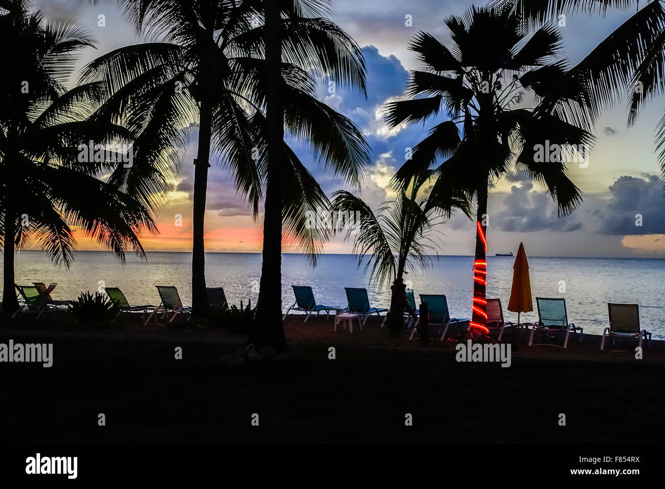 Landscape beachside resort Caribbean Sea beach chairs palm trees sunset. St. Croix, U.S. Virgin Islands. Stock Photo