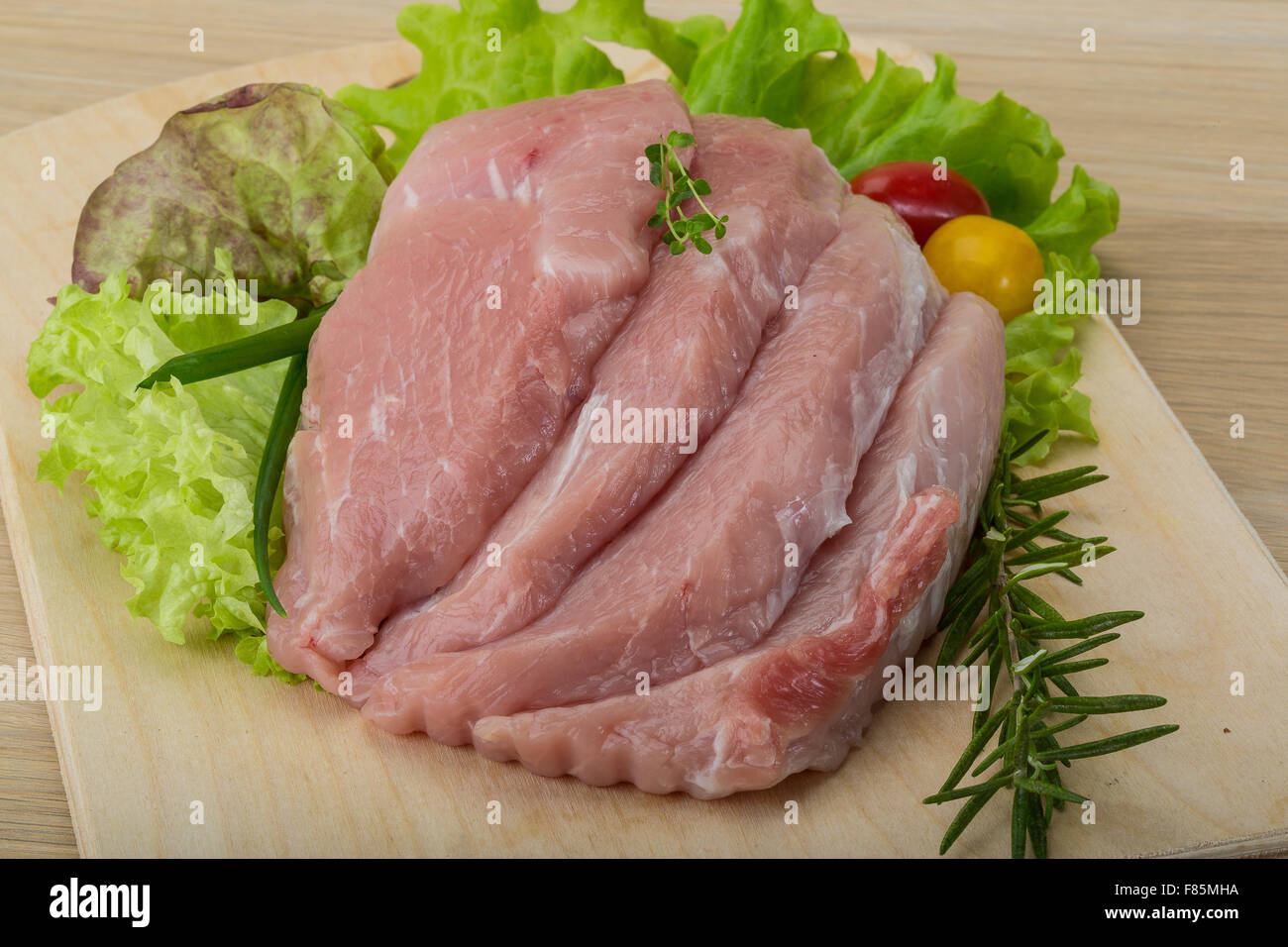 Raw pork schnitzel with rosemary and thyme Stock Photo - Alamy
