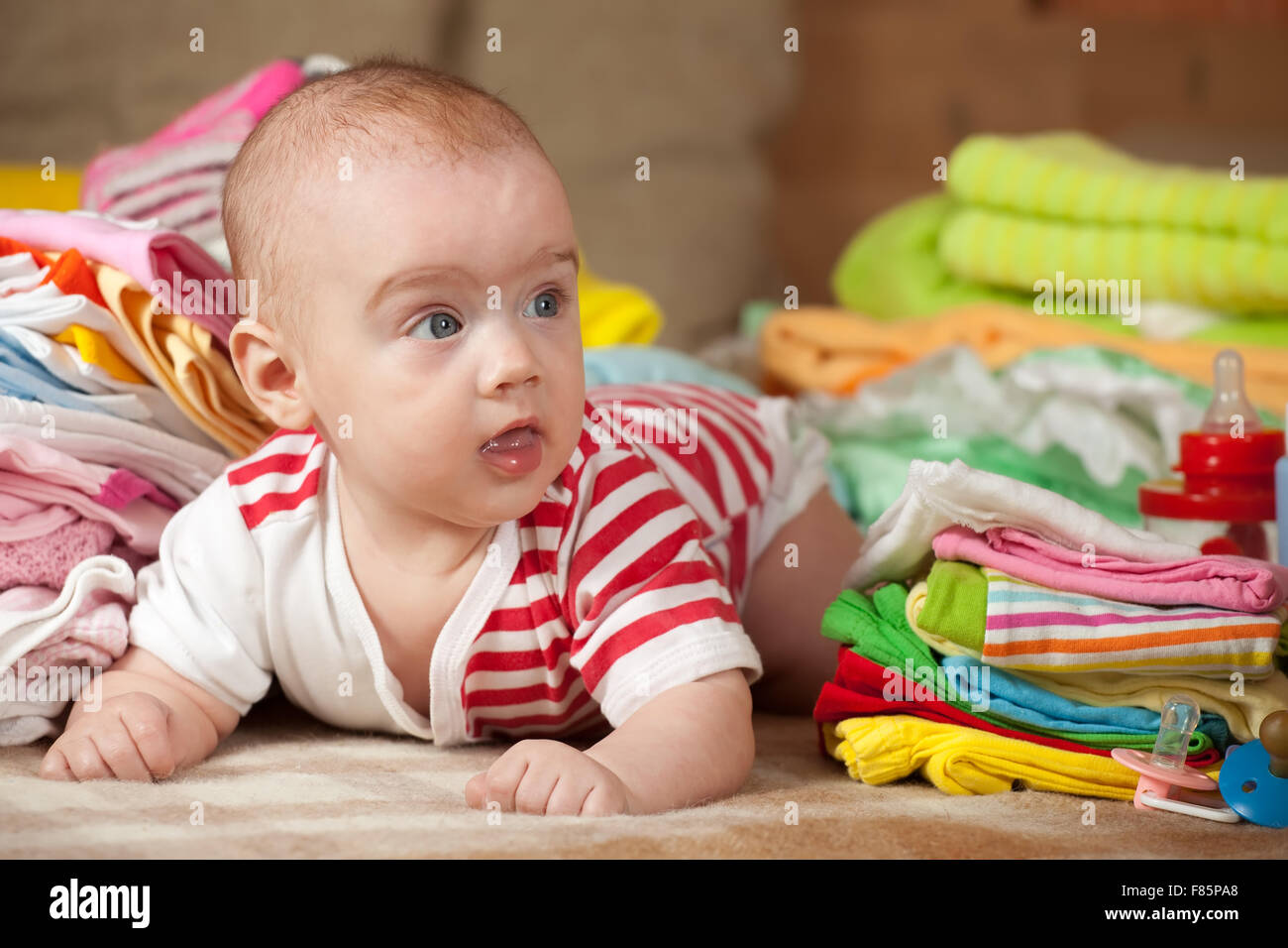 baby-girl-with-stacked-of-children-s-clothes-stock-photo-alamy