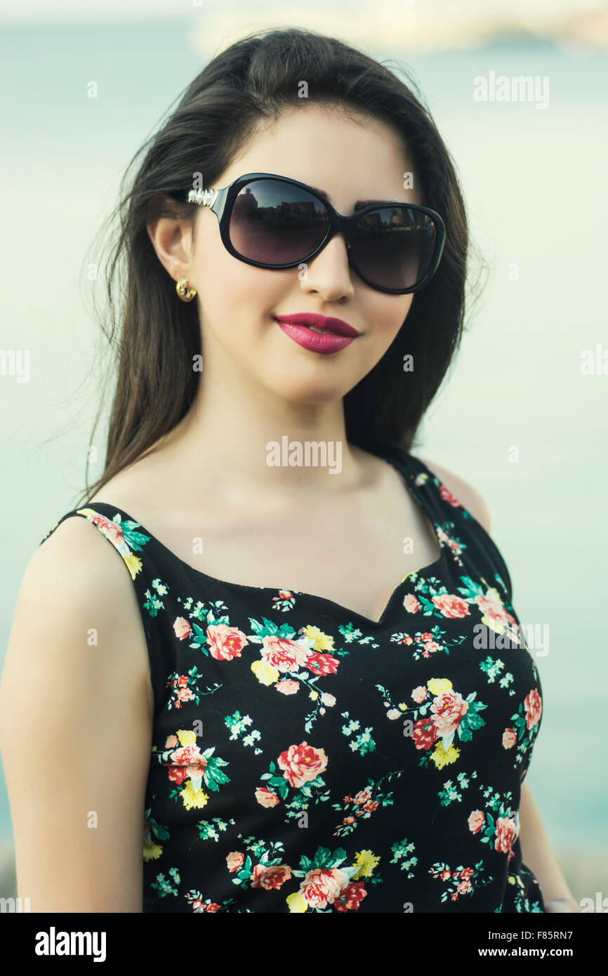 Happy young woman wearing sunglasses smiling outdoors Stock Photo - Alamy
