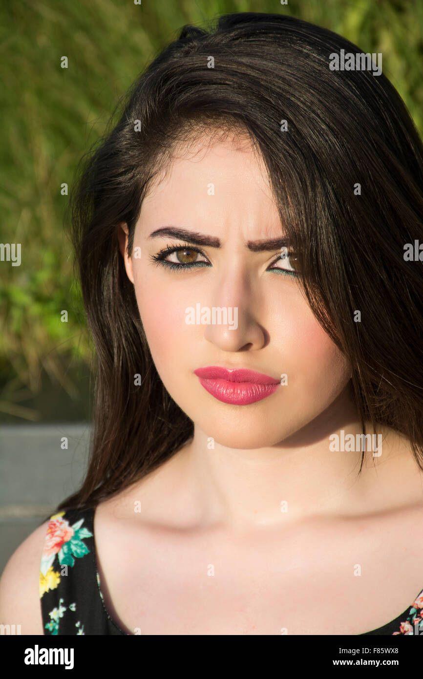 Serious young woman frowning outdoors Stock Photo
