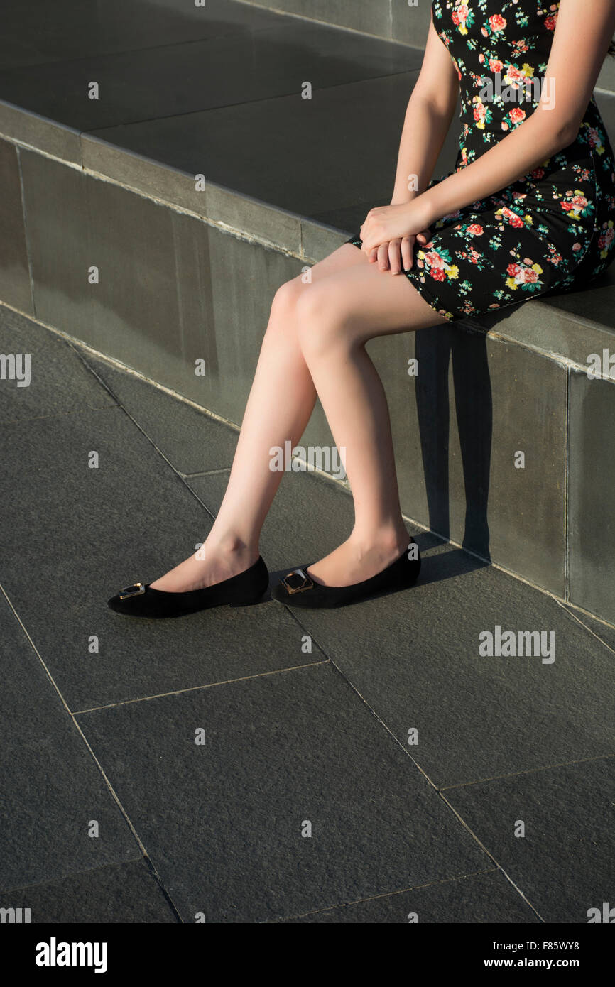 Young woman sat outdoors Stock Photo