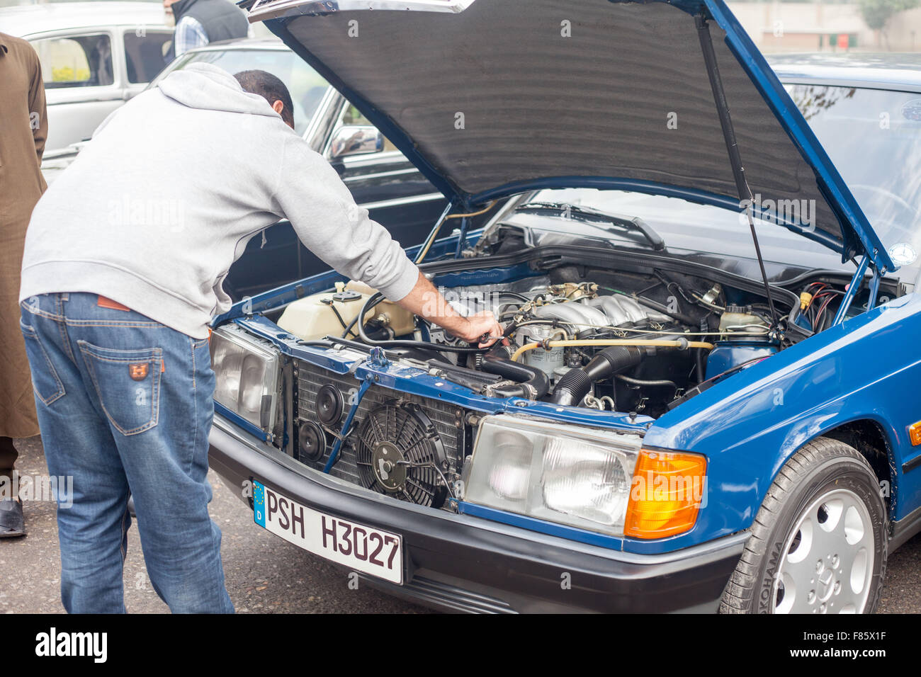 Owner of car is showing engine to people classic car show in Peshawar