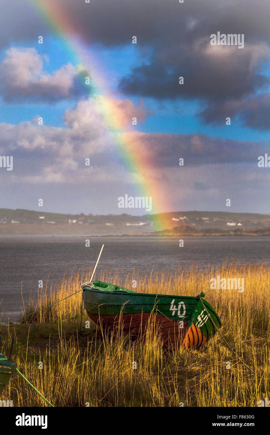 Ardara, County Donegal, Ireland Weather. 6th December 2015. After two days of incessant rain during Storm Desmond a rainbow appears over reed beds and fishing boats on the west coast. Credit:  Richard Wayman/Alamy Live News Stock Photo