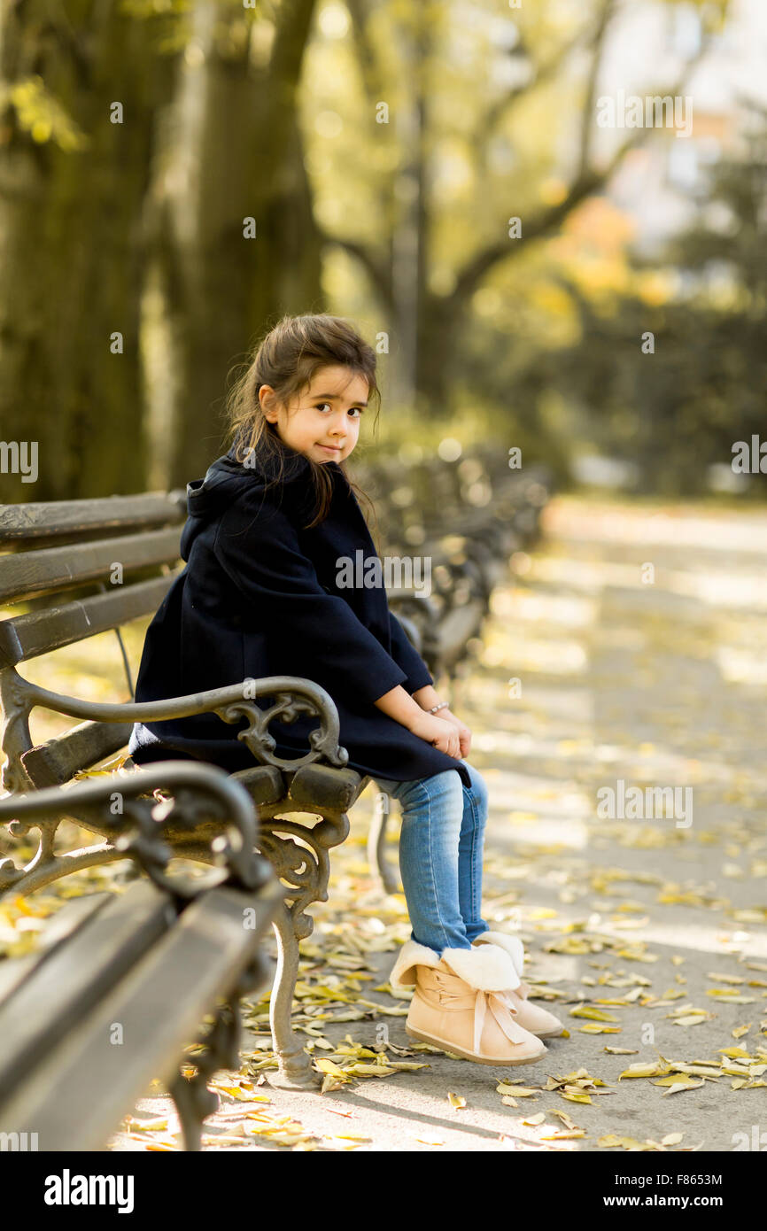 Little girl on the bench in the autumn park Stock Photo - Alamy
