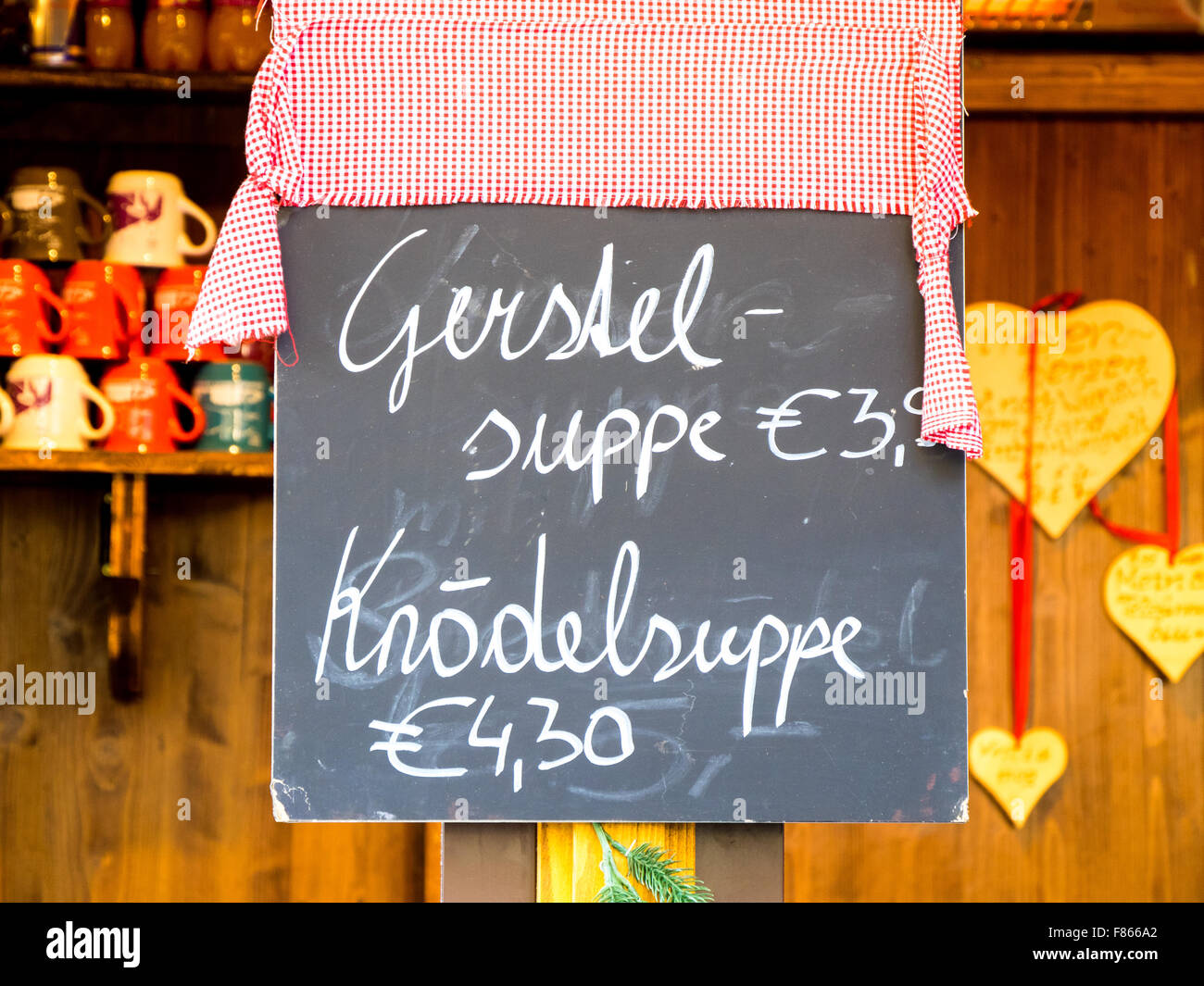 Hot food being sold at a Christmas market in Innsbruck, Austria. Chalk board hand written menu with items and prices listed. Stock Photo