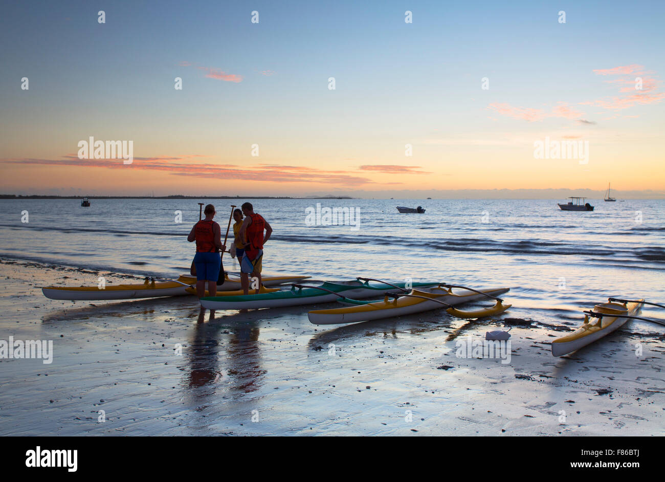 People with outrigger canoes at sunset, New Town Beach, Nadi, Viti Levu, Fiji Stock Photo