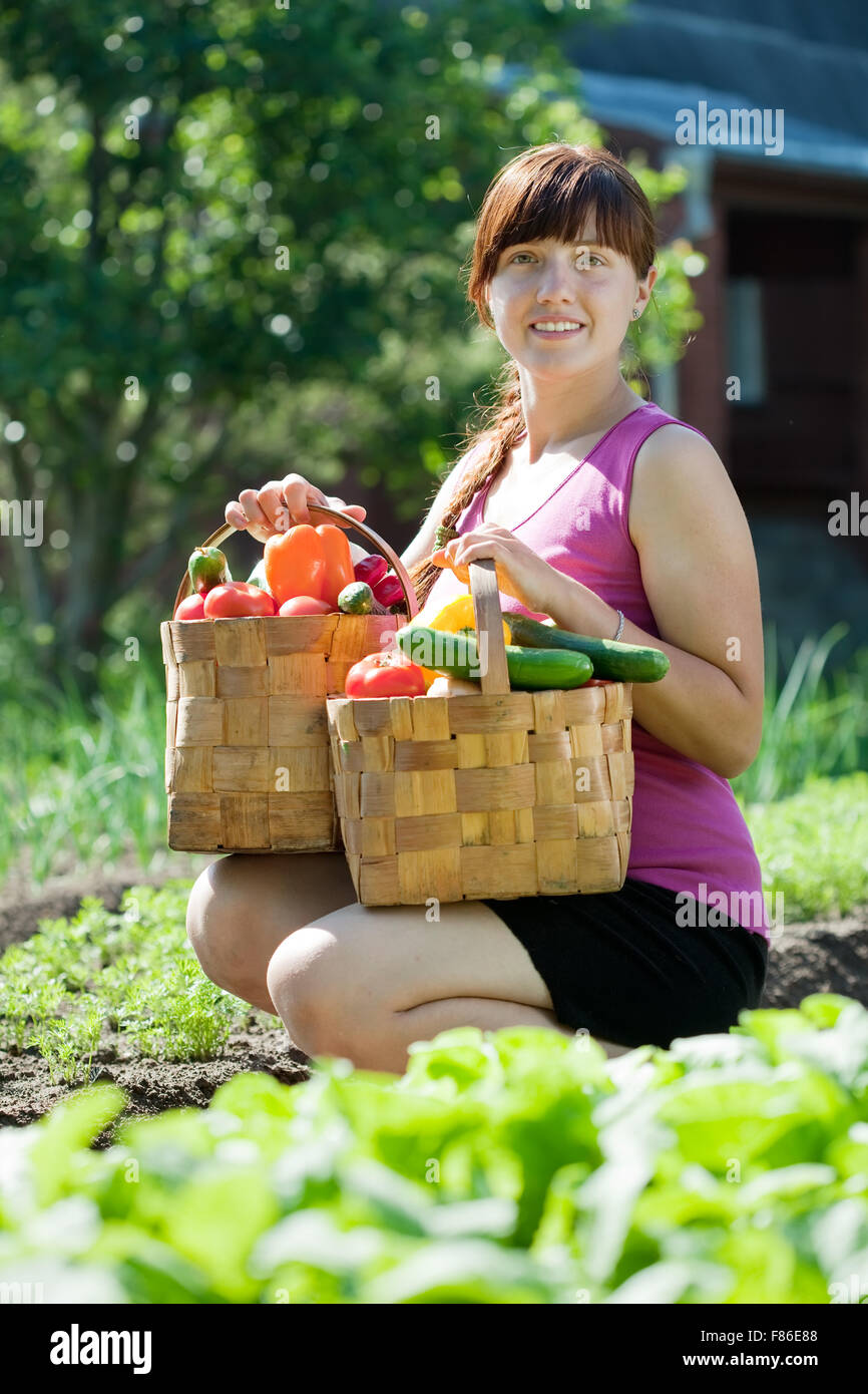 Happy young woman with vegetables harvest in garden Stock Photo - Alamy