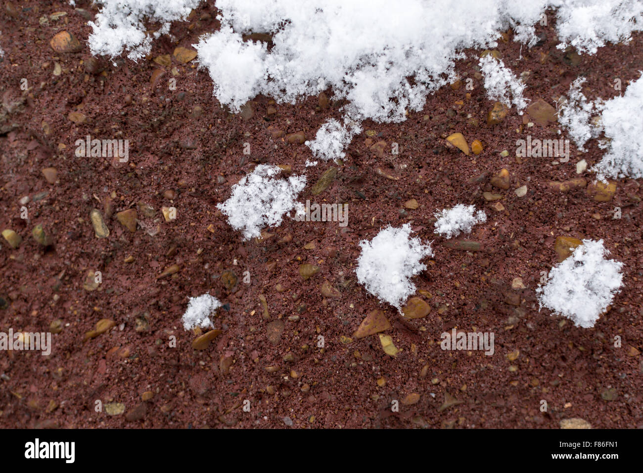 Fresh winter snow covers a red brick wall in the cold winter months Stock Photo