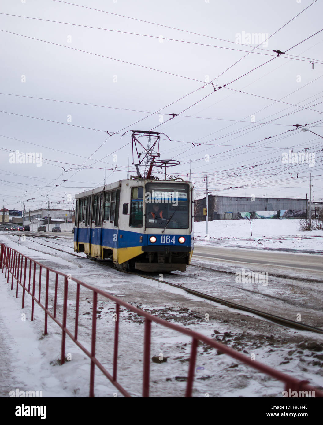 Colourful electric trolleybus in an industrial setting moves workers to places of work during the winter months in Ufa, Stock Photo
