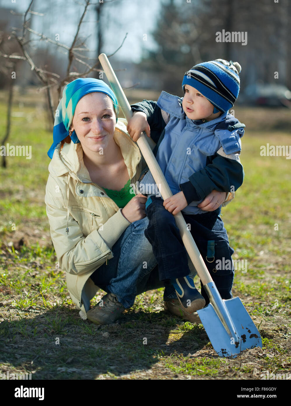young woman and boy working with spade in garden Stock Photo - Alamy