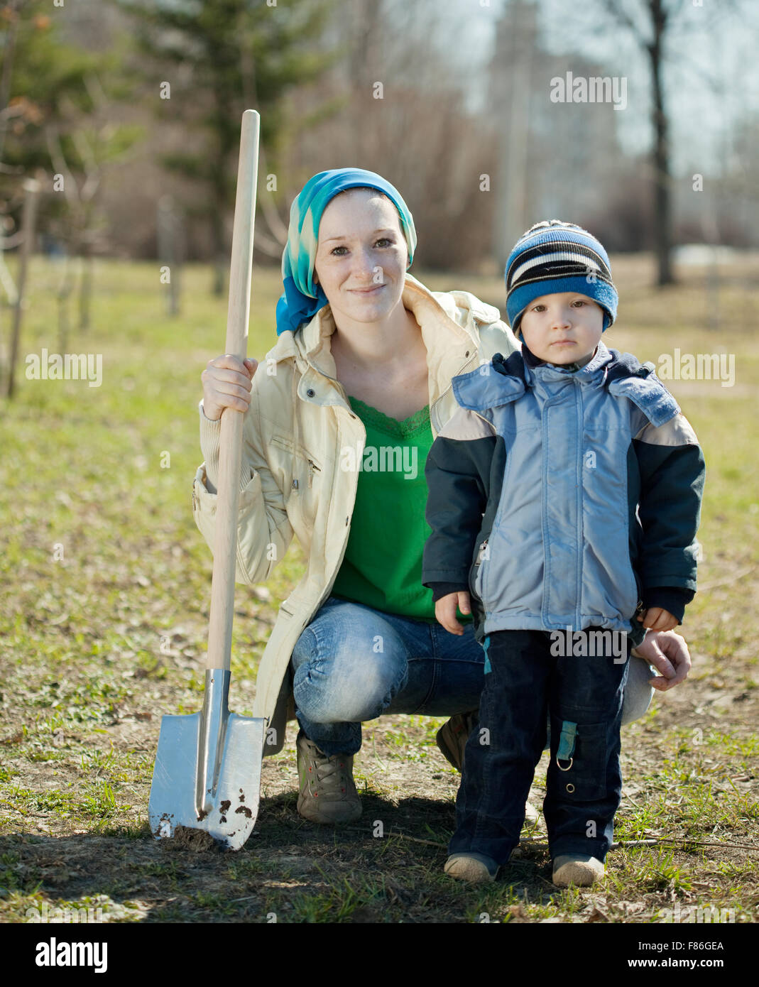 young woman and boy working with spade in garden Stock Photo - Alamy