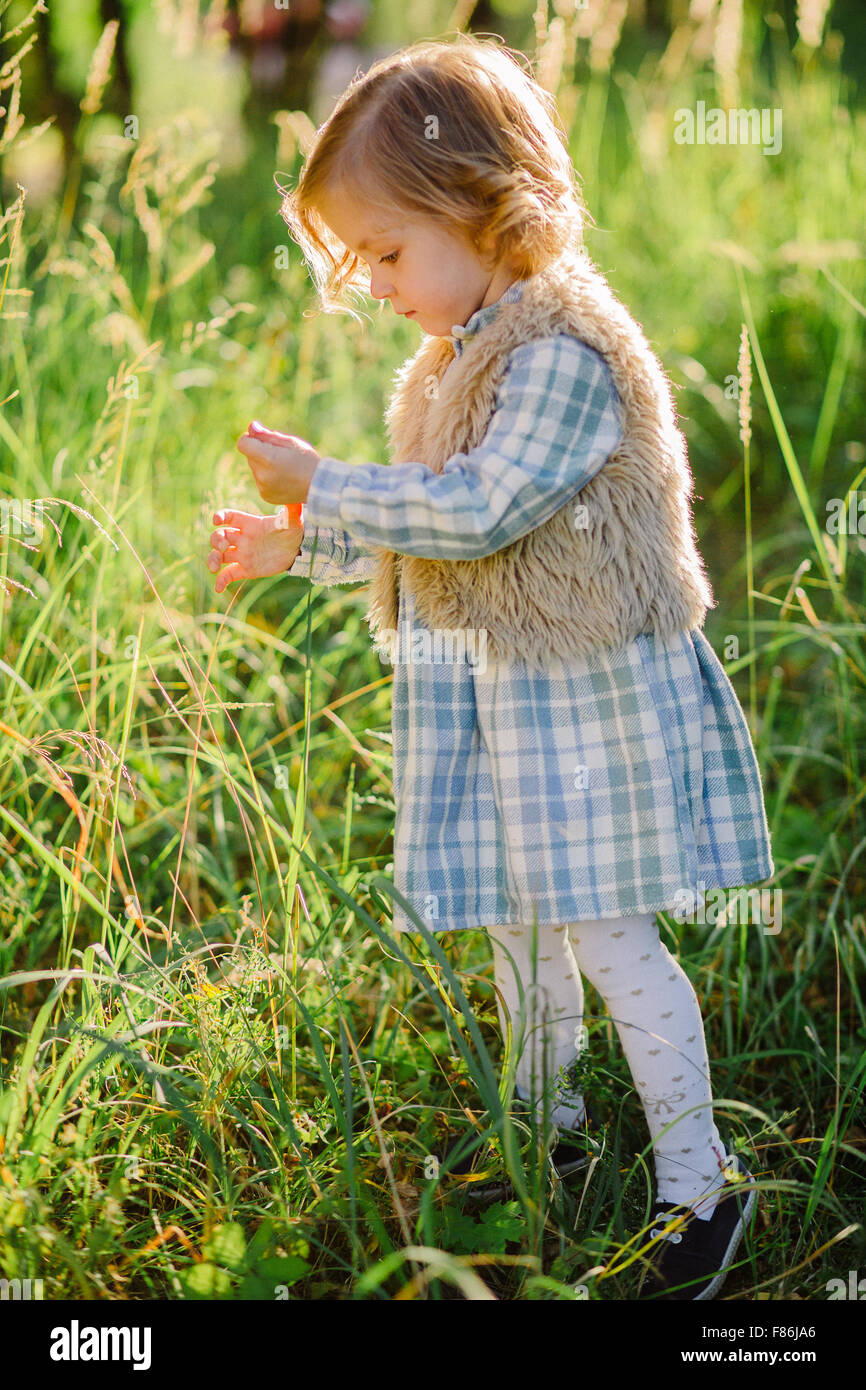 Cute girl in a green field in sunset Stock Photo - Alamy