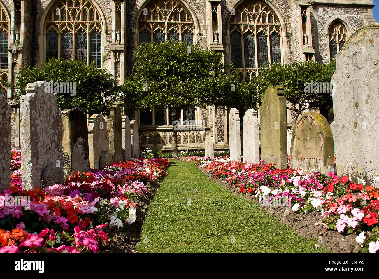 Colourful flowers next to grave stones Stock Photo