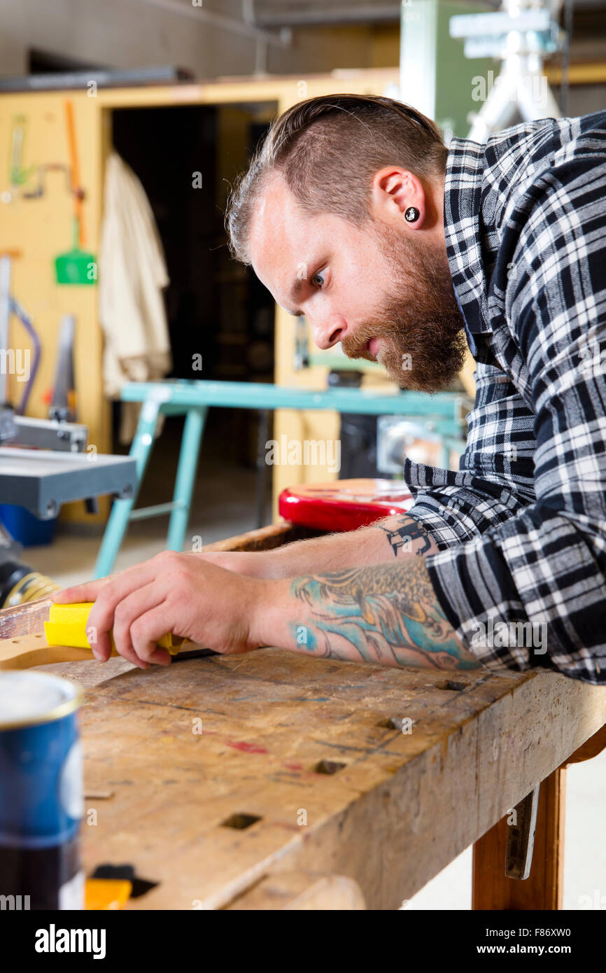 Craftsman sanding a guitar neck in wood at Stock Photo Alamy