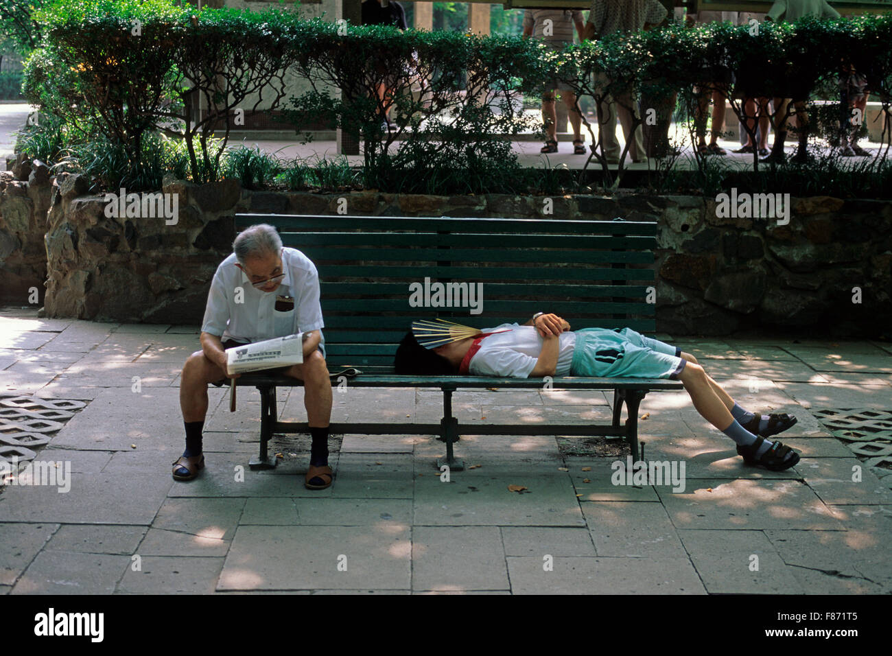 Old man and young man relaxing on a bench at  Xiang Yang Park, Shanghai, China, Asia Stock Photo