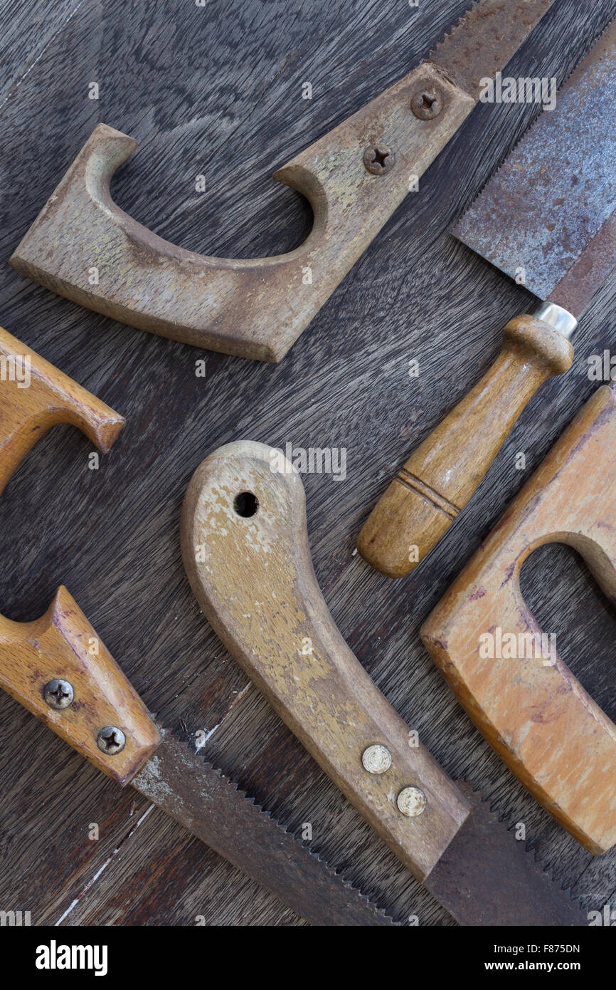 wooden handles of old saws / old handsaws details on wooden background Stock Photo
