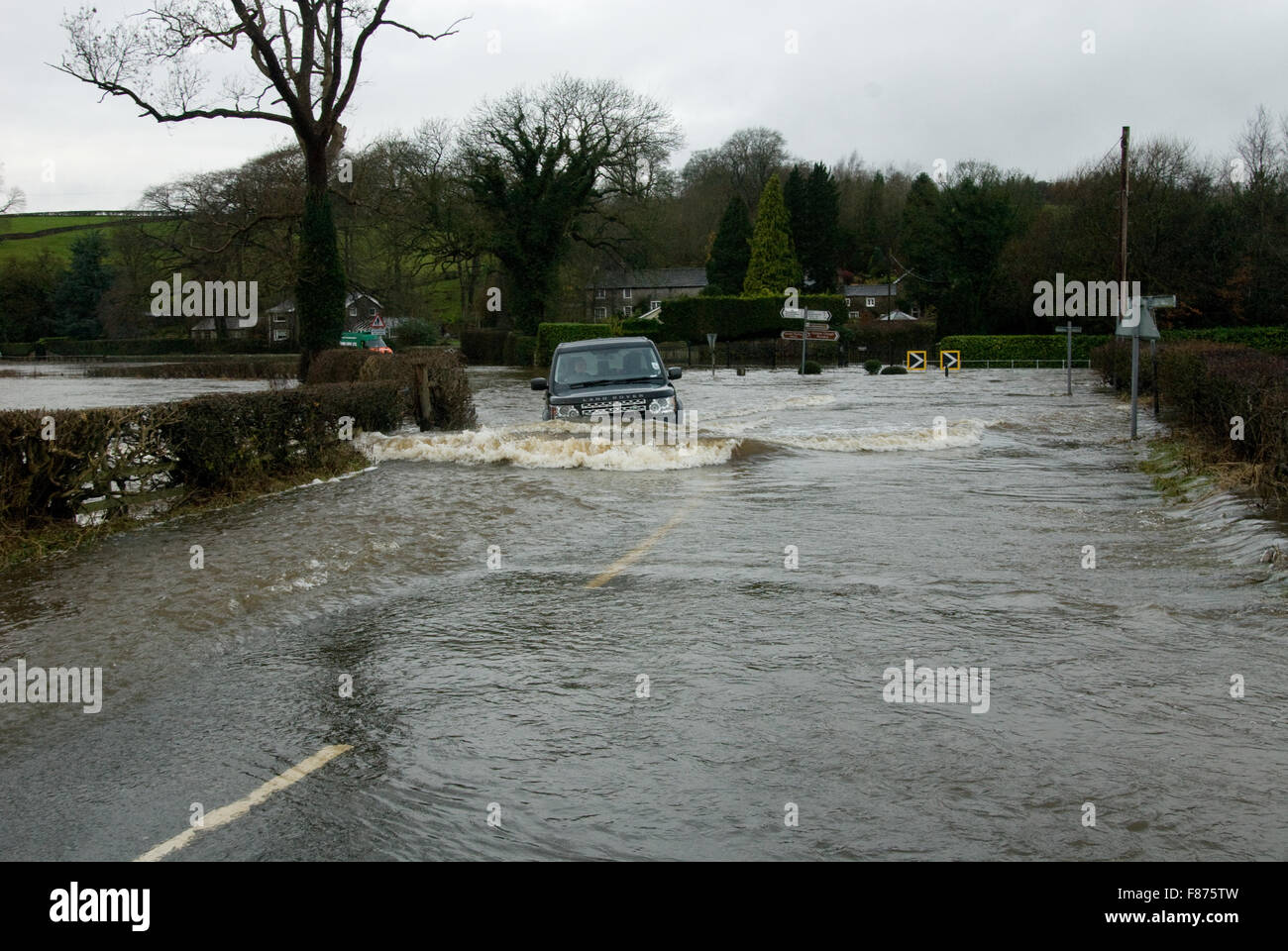 The driver of a Land Rover Discovery is not deterred by extreme flooding in Sawley, Lancashire caused by Storm Desmond. Stock Photo