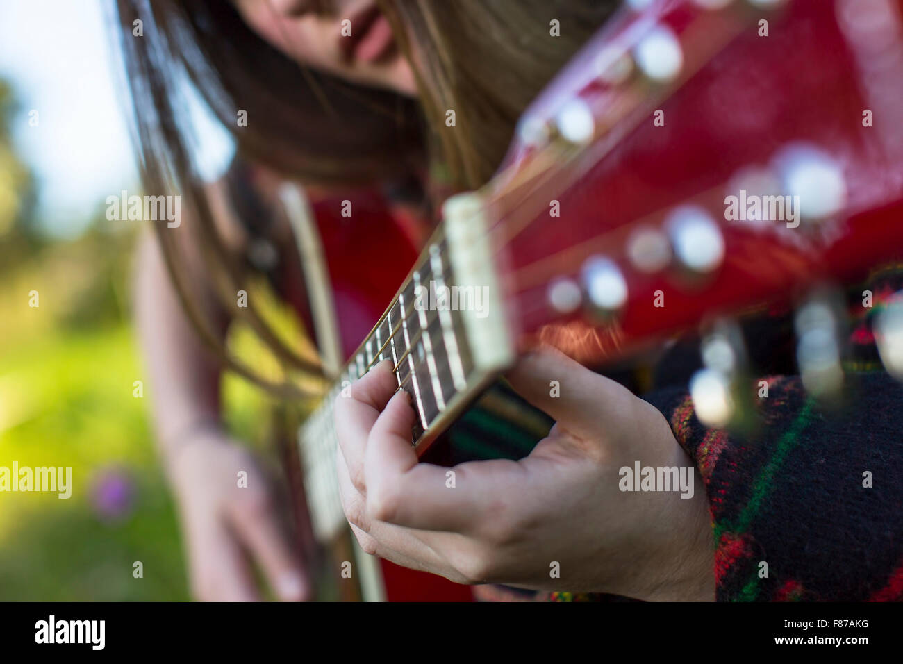Hands of a young girl on the frets of acoustic guitar. Stock Photo