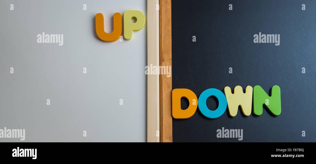 Wooden word UP and DOWN on black board and white board Stock Photo - Alamy