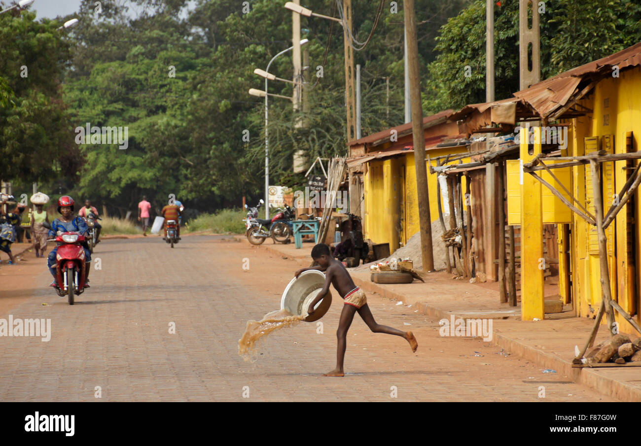 Boy throwing dirty water in the street in front of houses, Abomey, Benin Stock Photo Alamy