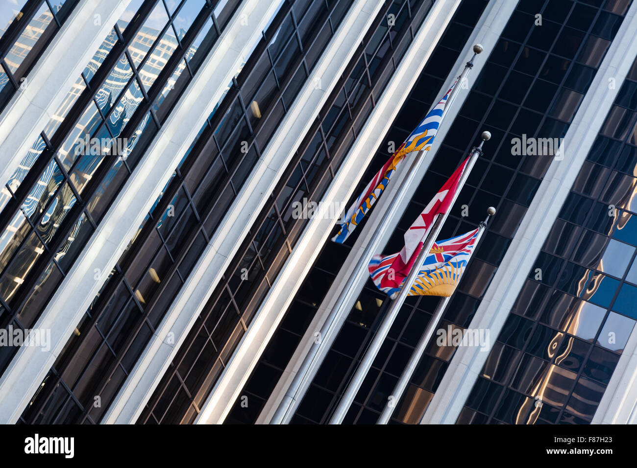 Canadian and British Columbian flags flying in downtown Vancouver Stock