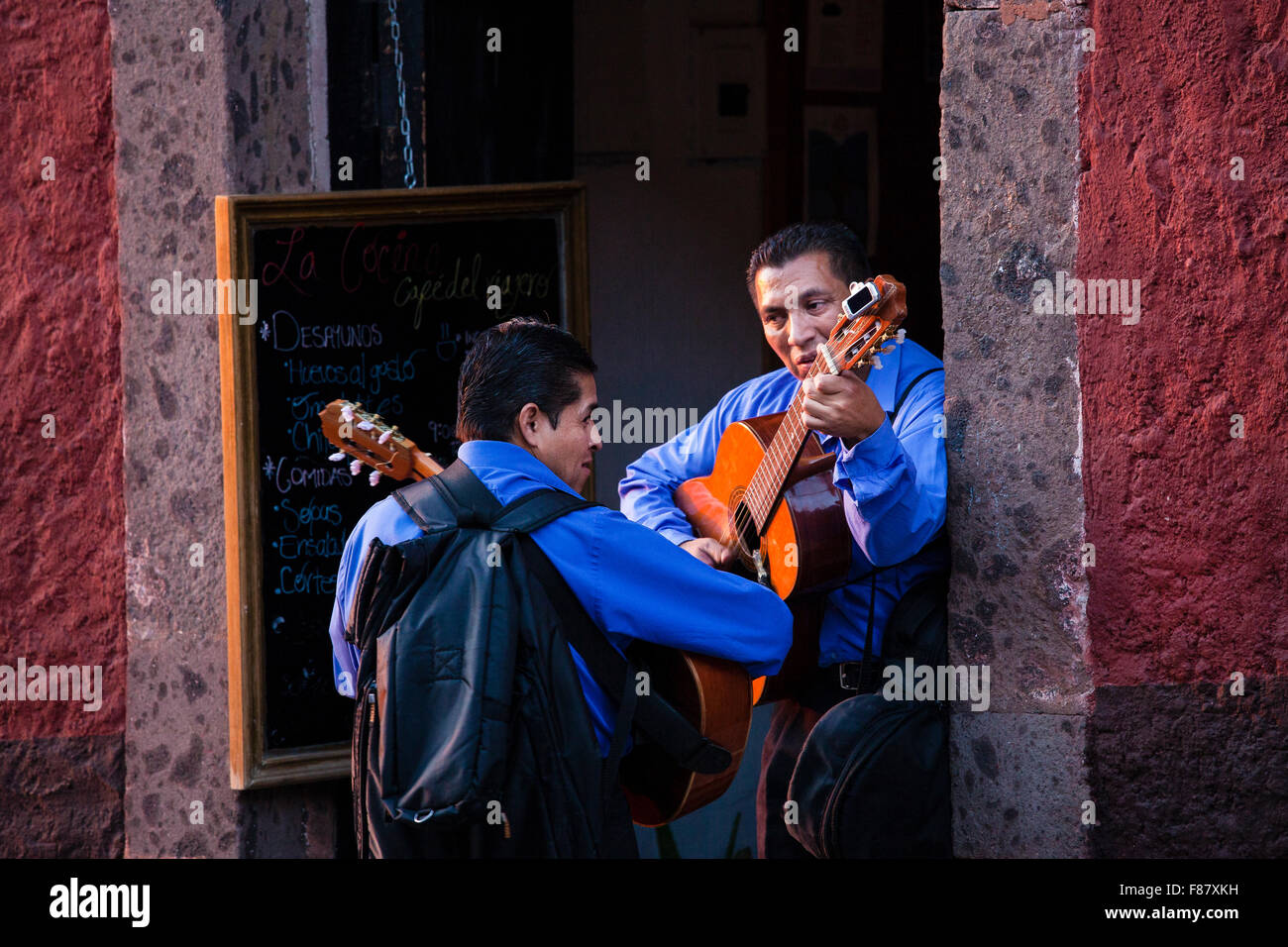 A couple of guitar players rehearse a tune before entering a restaurant in San Miguel de Allende, Mexico. Stock Photo
