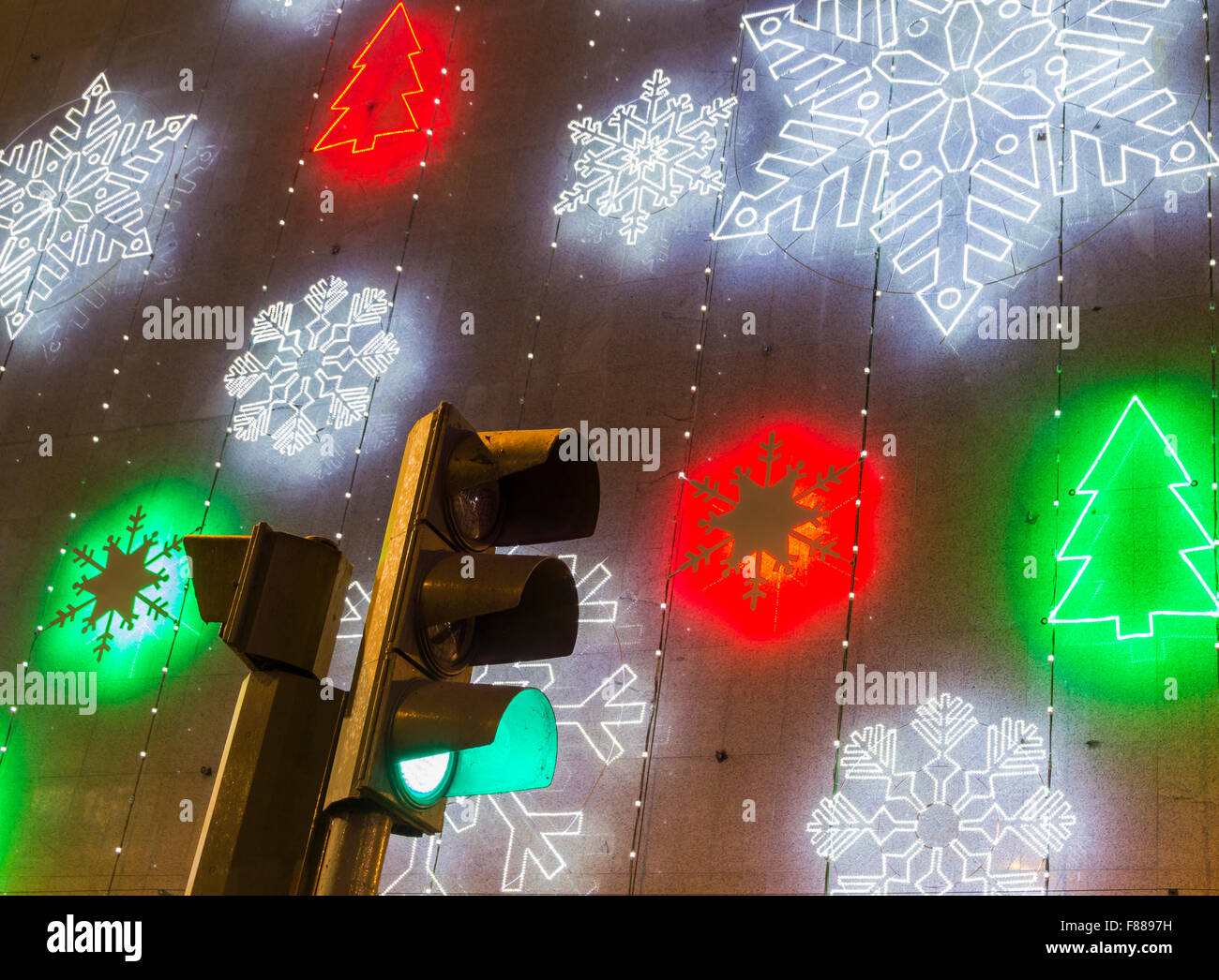 Green traffic light with christmas lights on department store in