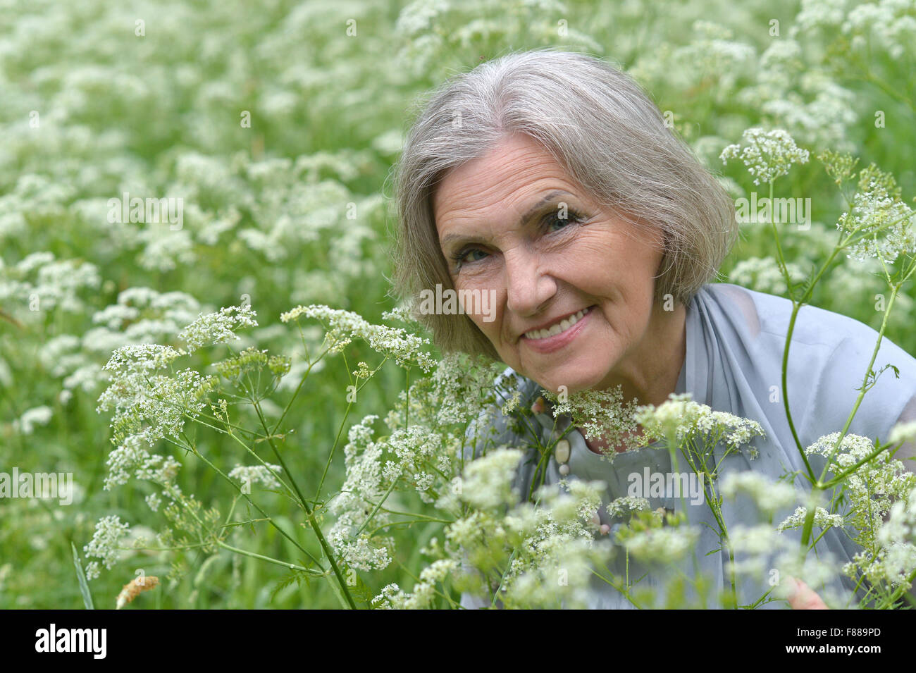 Senior woman with flowers Stock Photo - Alamy