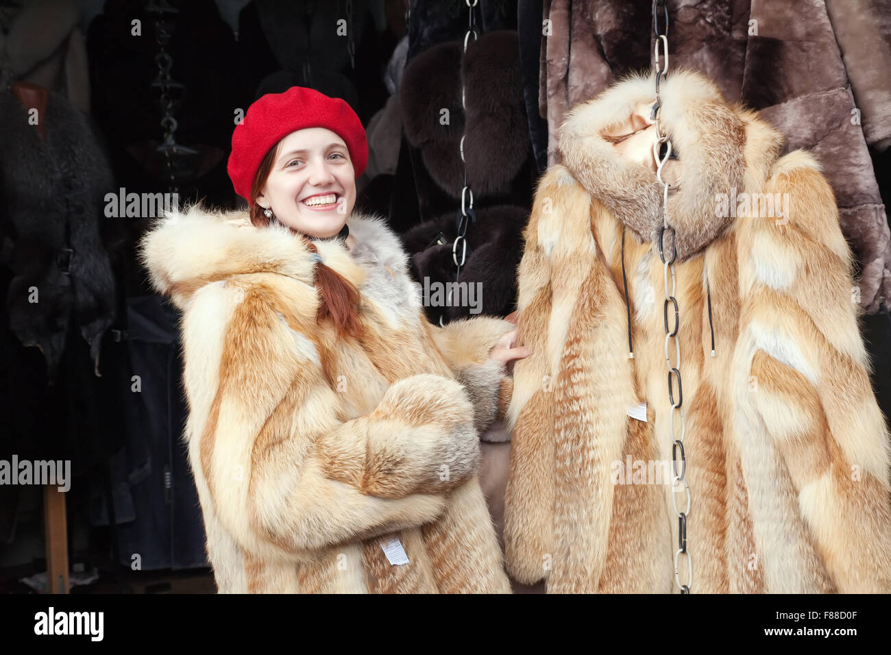 Woman chooses fur coat at fashionable shop Stock Photo Alamy