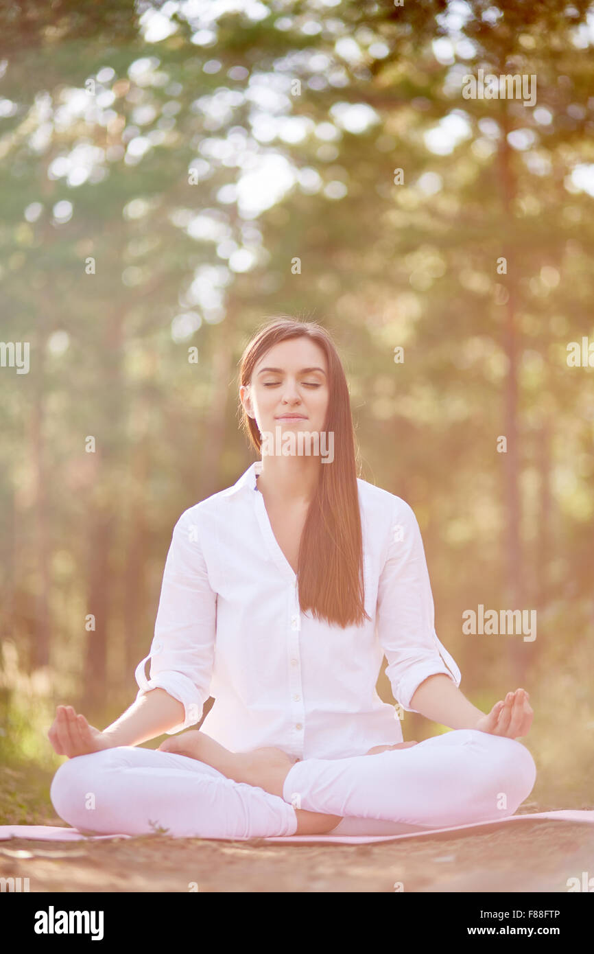 Young woman sitting in yoga pose with eyes closed and meditating Stock ...