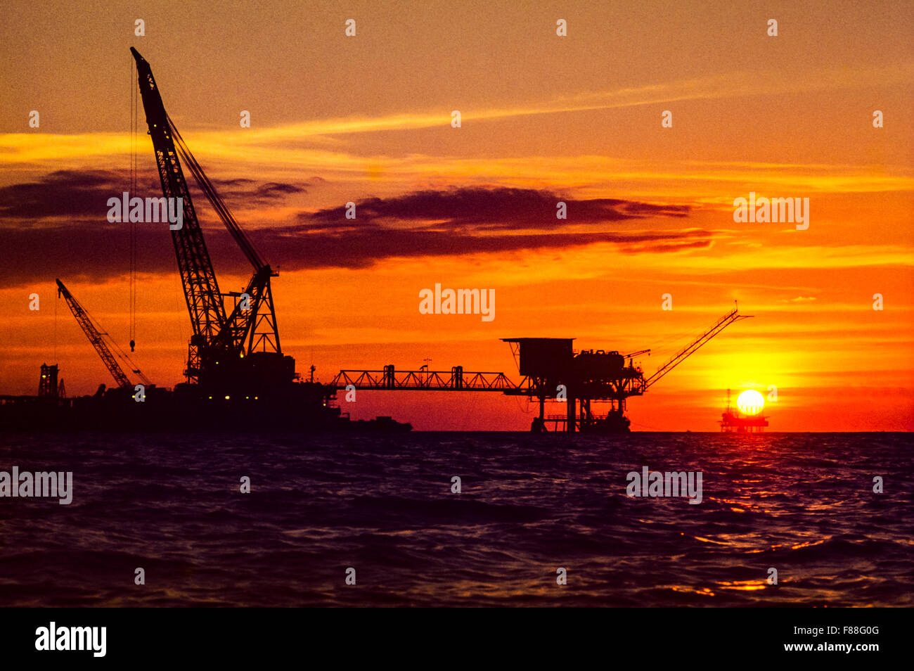 Offshore oil drilling rig with rising sun, Philippines, South East Asia Stock Photo