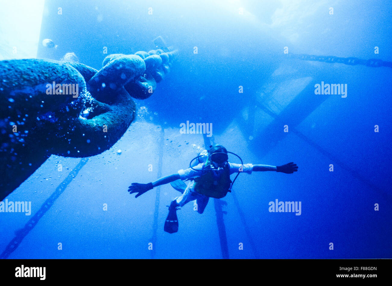 Scuba diver swimming under offshore oil rig, underwater worker, Thailand, South-East Asia Stock Photo