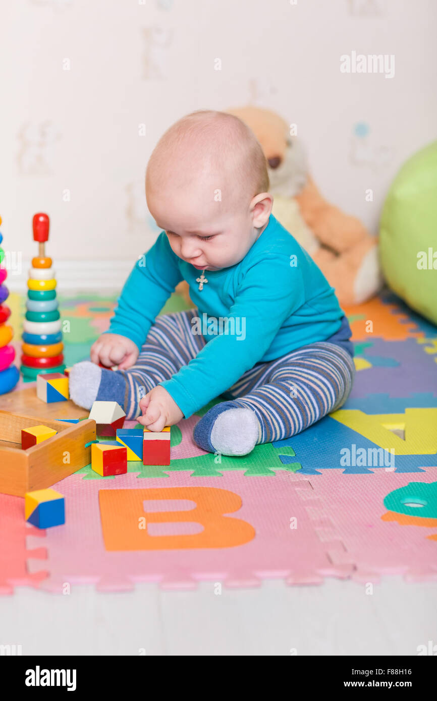 Cute little baby playing with colorful toys Stock Photo - Alamy