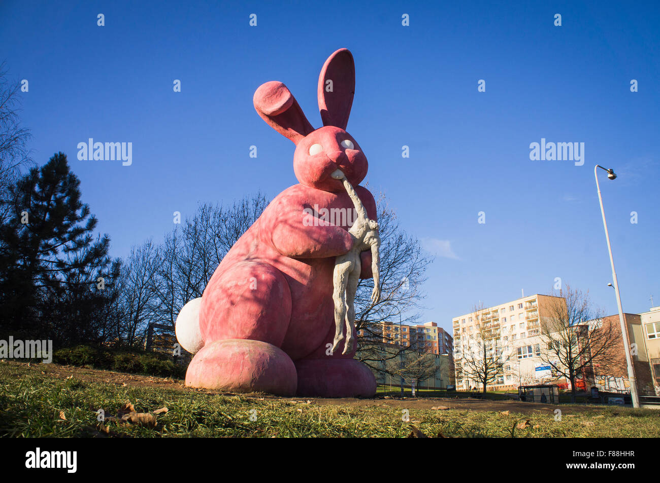 giant pink rabbit eating a headless human body statue Stock Photo - Alamy