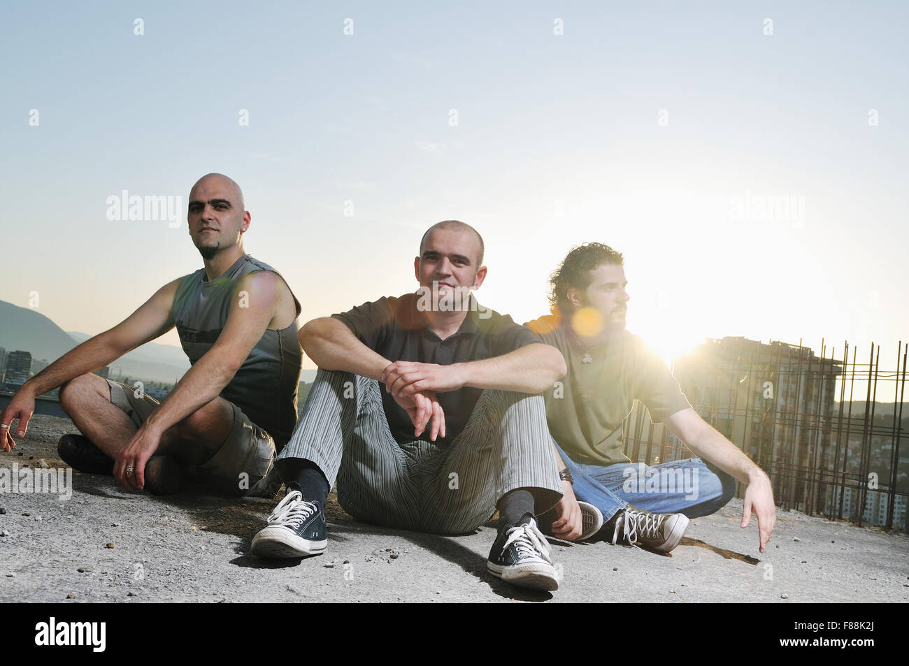 group of three adult man outdoor in the city at the sunset representing ...