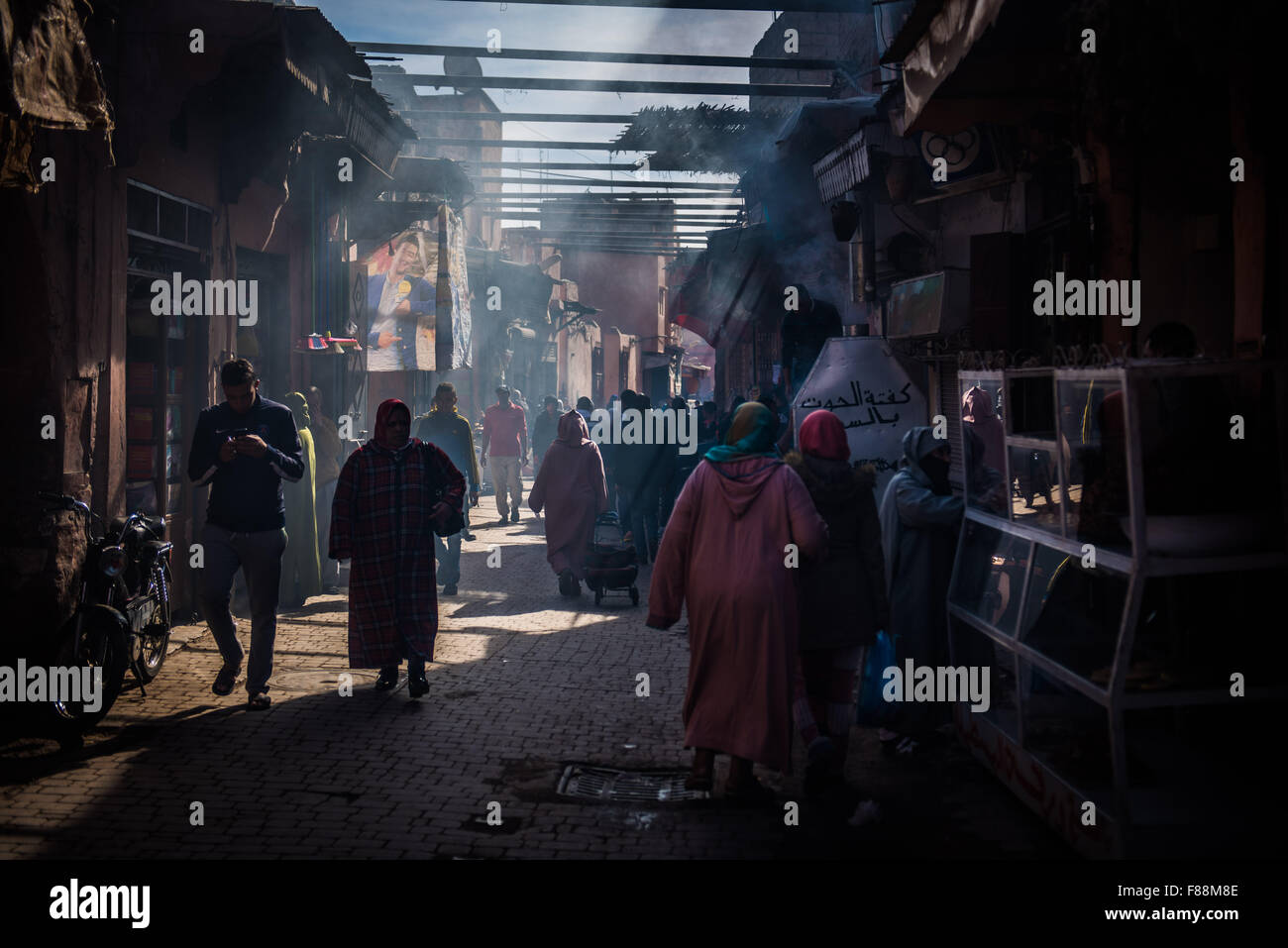 Rays of light piecing the smoke in the souk in Marrakesh Stock Photo