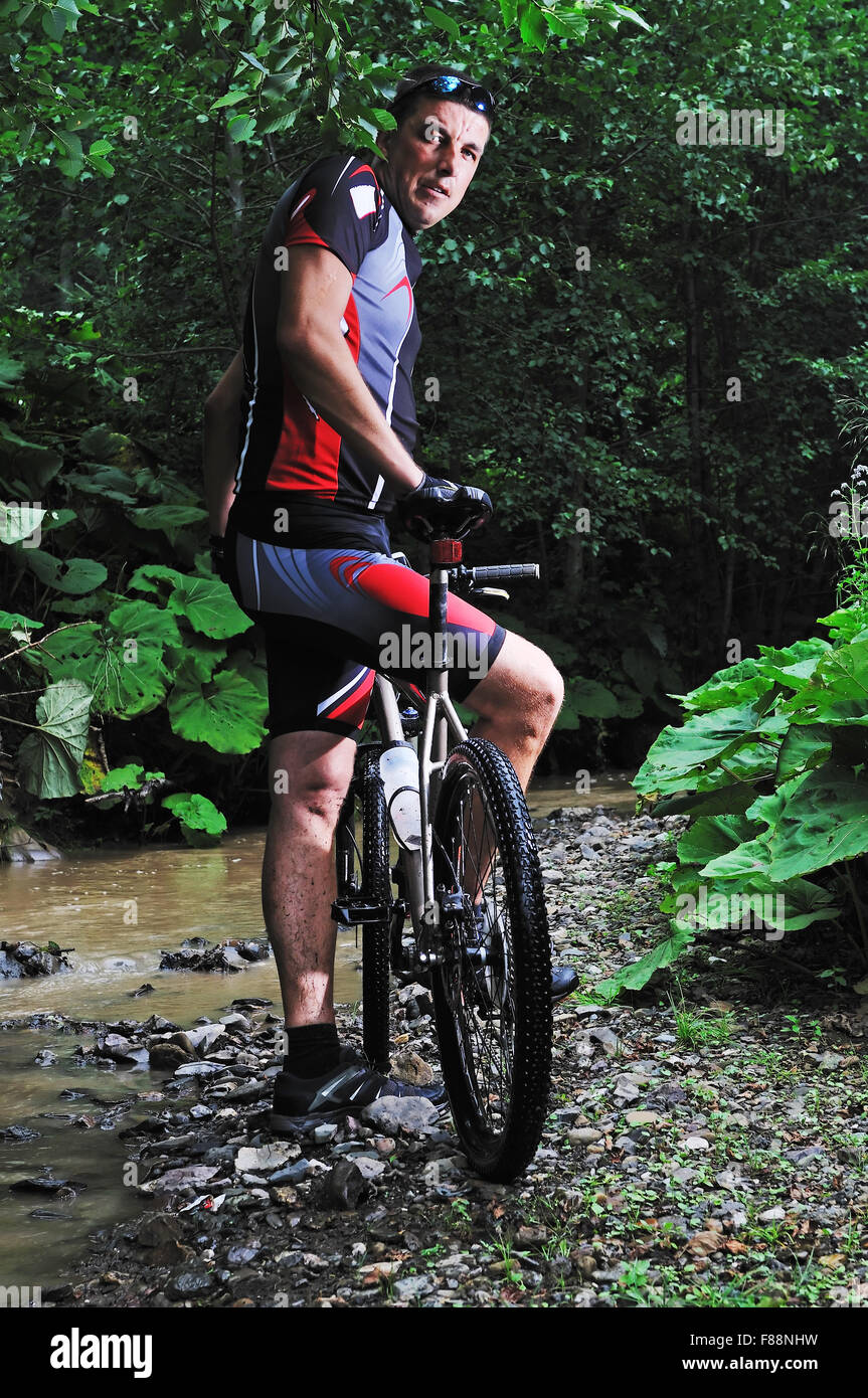 young man drive mountain bike over water river Stock Photo Alamy