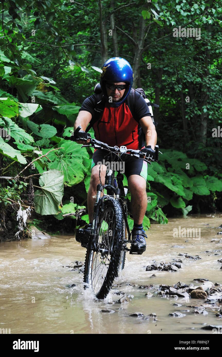 young man drive mountain bike over water river Stock Photo Alamy
