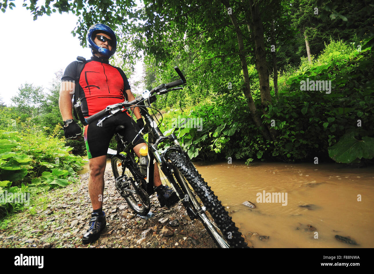 young man drive mountain bike over water river Stock Photo Alamy